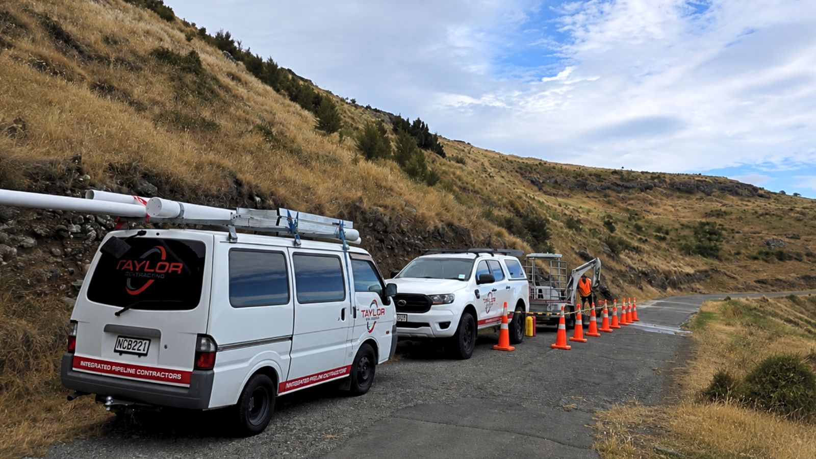 Taylor Plumbing van, ute and mini excavator on a Wellington job site